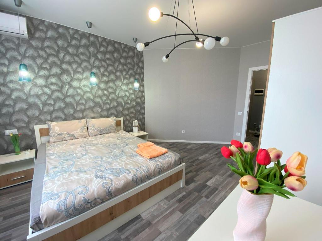 a bedroom with a bed and a vase of flowers at FlatService Апартаменти в сучасному ЖК Parklend in Kyiv