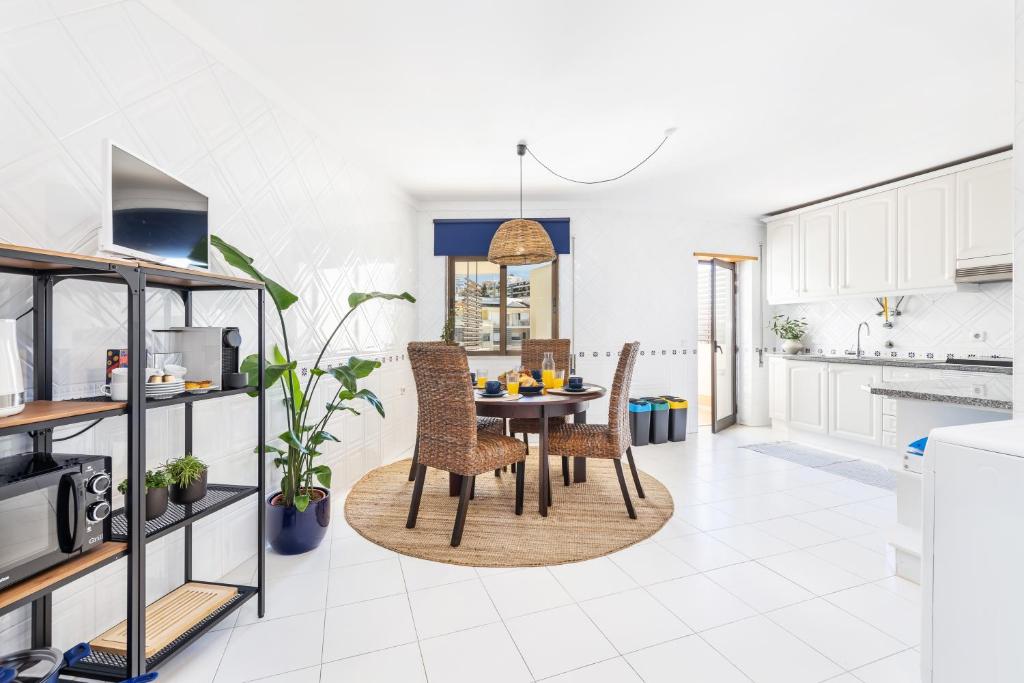 een keuken en eetkamer met een tafel en stoelen bij Downtown Poet´s Apartment in Faro