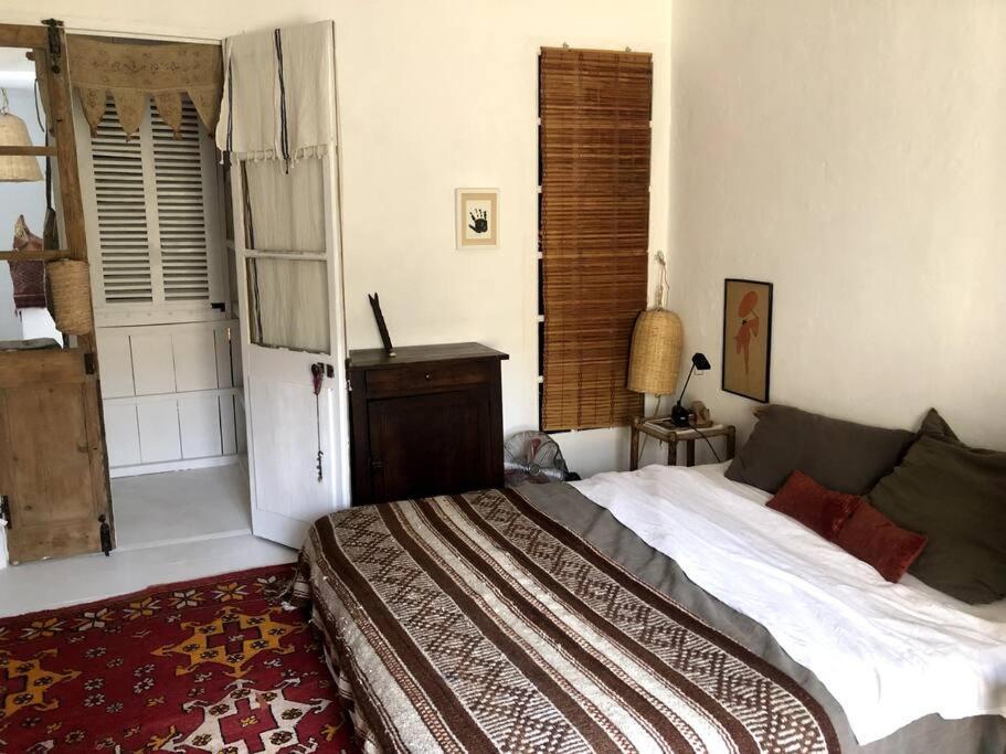 a bedroom with a large bed and a window at Atypical Town House in Uzès. in Uzès