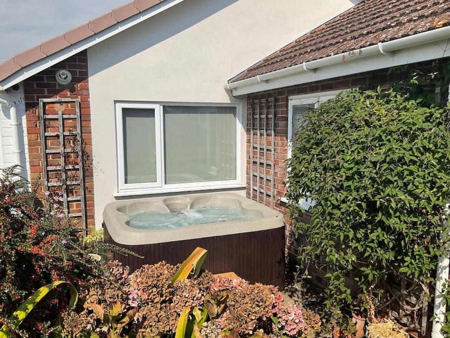 a bath tub in the backyard of a house at Hot Tub Beach Bungalow - free parking & child friendly in South Hayling