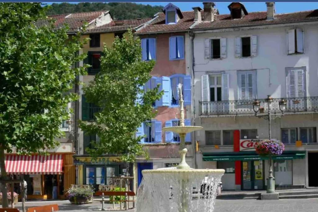 a fountain in the middle of a street with buildings at Maison Centrale in Ax-les-Thermes