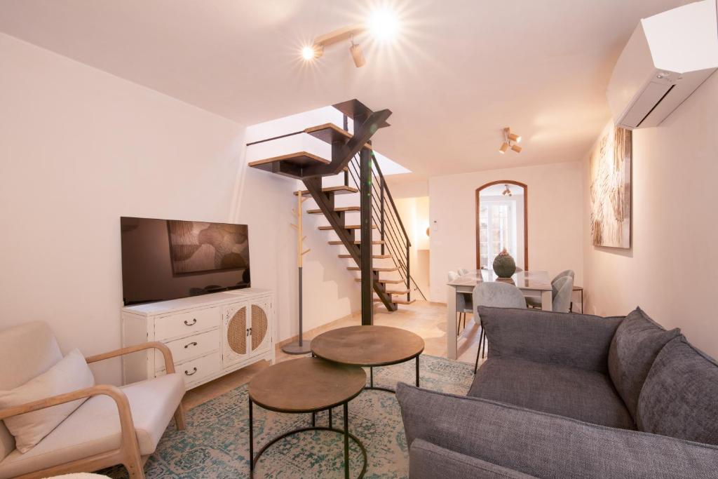 a living room with a couch and a spiral staircase at Pick A Flat's Townhouse in Saint-Tropez - Rue Sainte-Barbe in Saint-Tropez