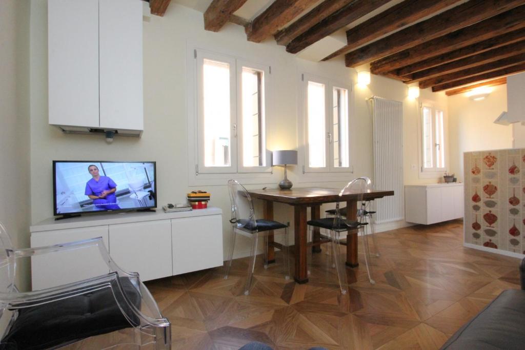 a living room with a dining room table and a tv at City Apartments Salute-Accademia in Venice