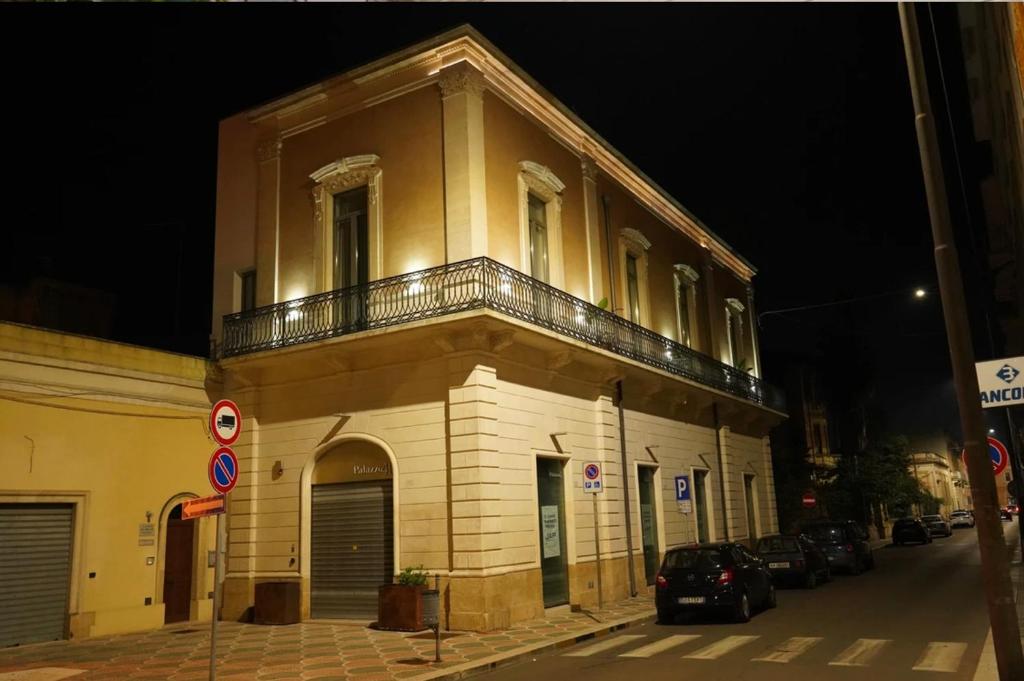 un edificio con balcón en el lateral de una calle en Palazzo 41 Rental Rooms, en San Pietro Vernotico