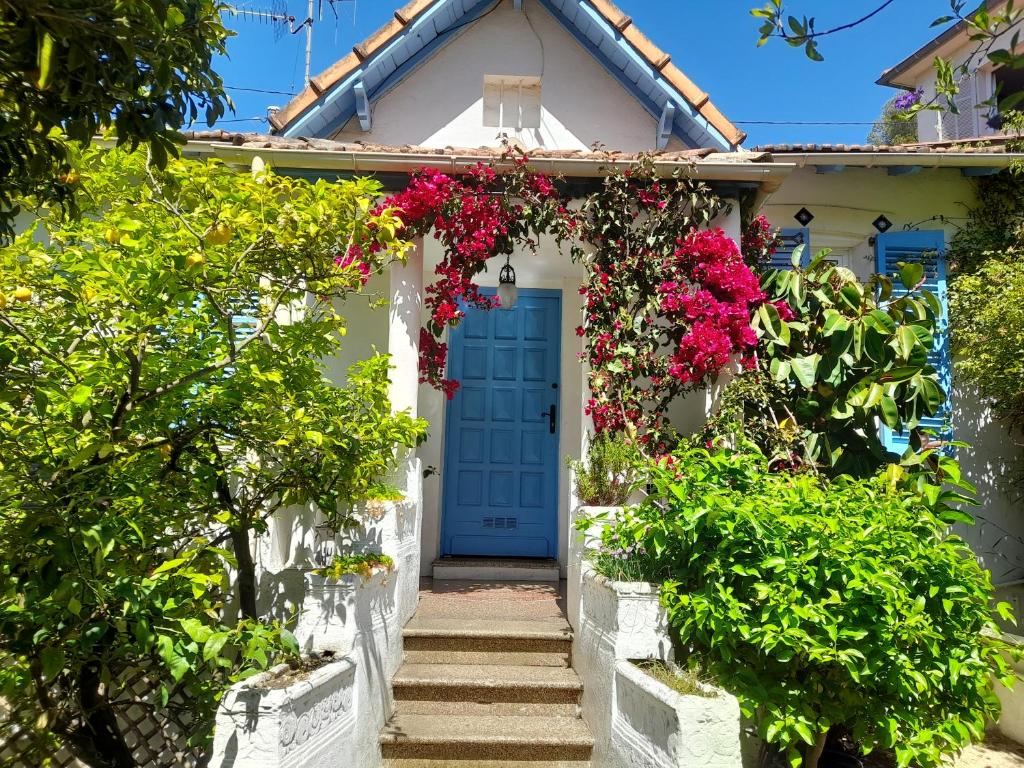 una casa bianca con una porta blu e fiori di Au fil de l eau a Cannes