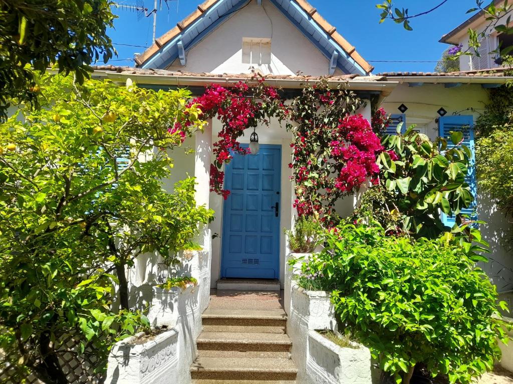 a white house with a blue door and flowers at Au fil de l eau in Cannes