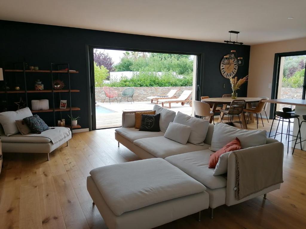 a living room with a white couch and a table at Villa T4 avec piscine in Lucciana