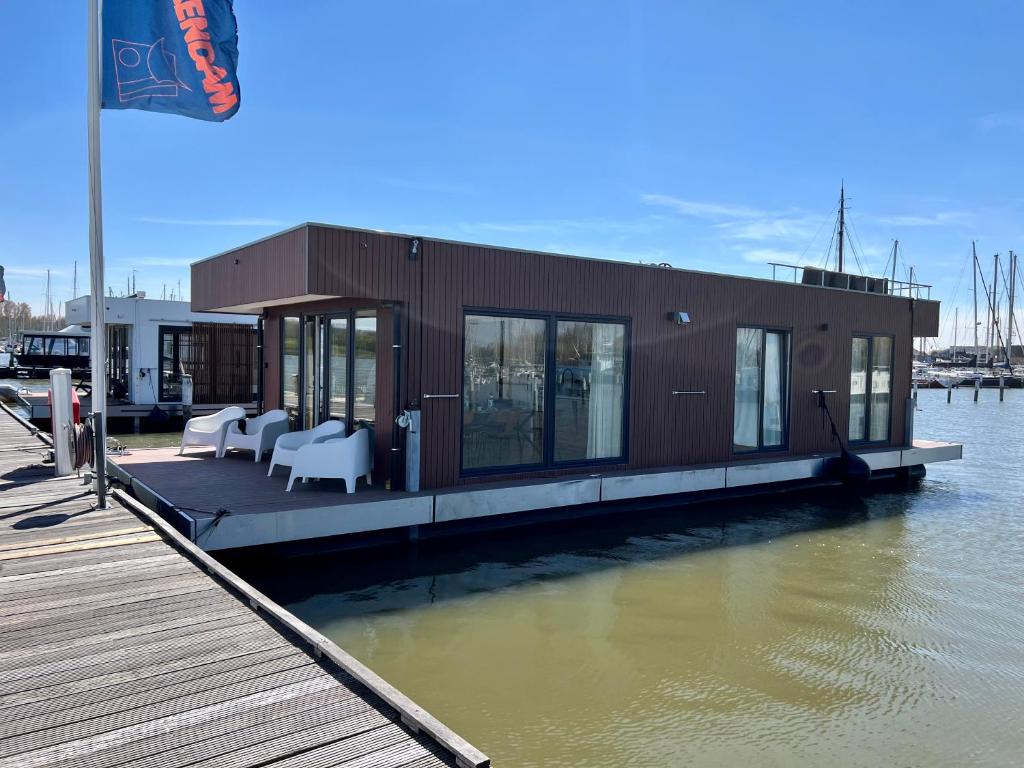 a small house on a dock on the water at Surla luxury sailing Houseboat Splendid at Marina Monnickendam in Monnickendam
