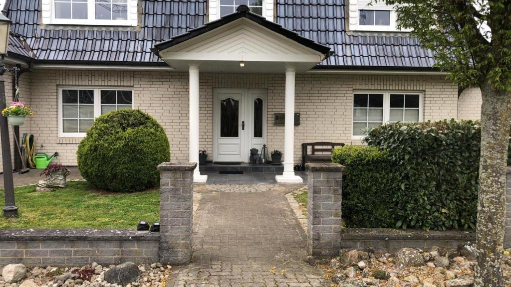 a house with a brick walkway leading to the front door at Marina, Ferienwohnung in Schneverdingen