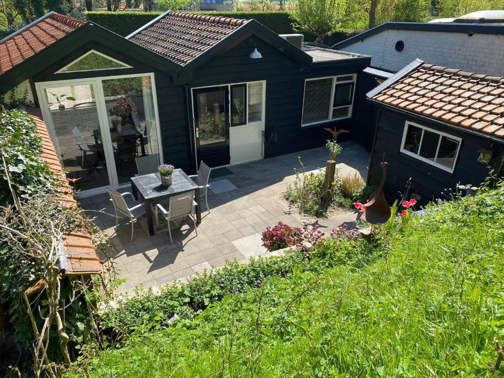 a patio with a table and chairs in front of a house at Zandrijk in Egmond aan den Hoef