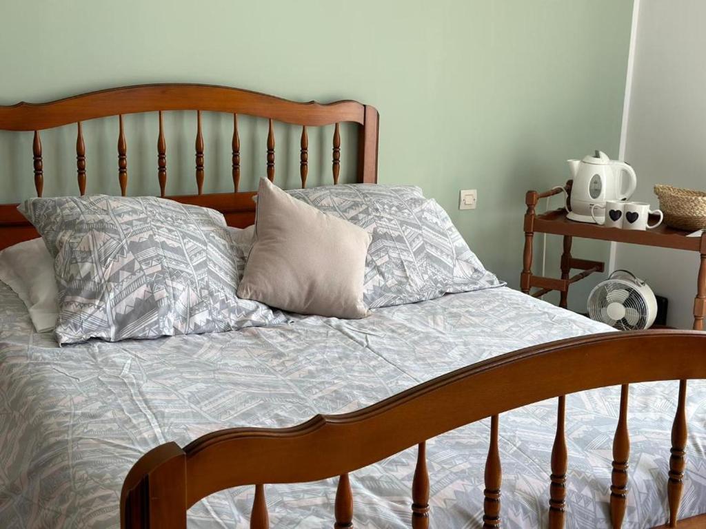 uma cama com uma cabeceira em madeira e uma almofada em Les Cigales em Villelaure