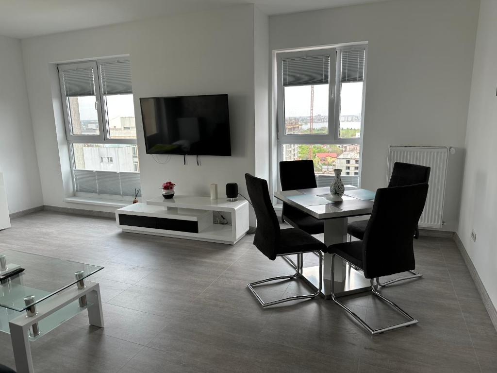 布加勒斯特的住宿－Fabulous Penthouse Lakeview W20，客厅配有桌椅和电视。
