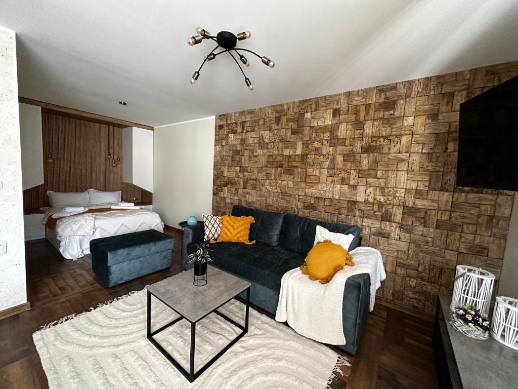 un soggiorno con divano blu e muro di mattoni di Апартамент НИА a Velingrad