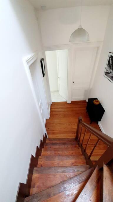 a staircase in a house with wooden floors and white walls at Le Domaine : maison proche de la plage et du port in Fécamp