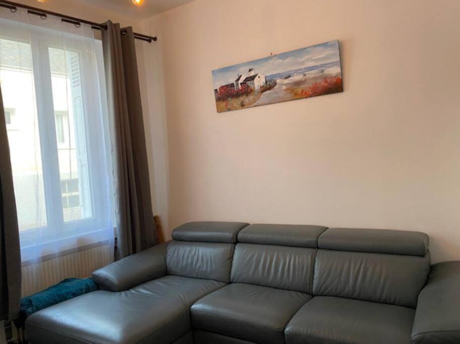 a living room with a couch and a painting on the wall at Le Domaine : maison proche de la plage et du port in Fécamp