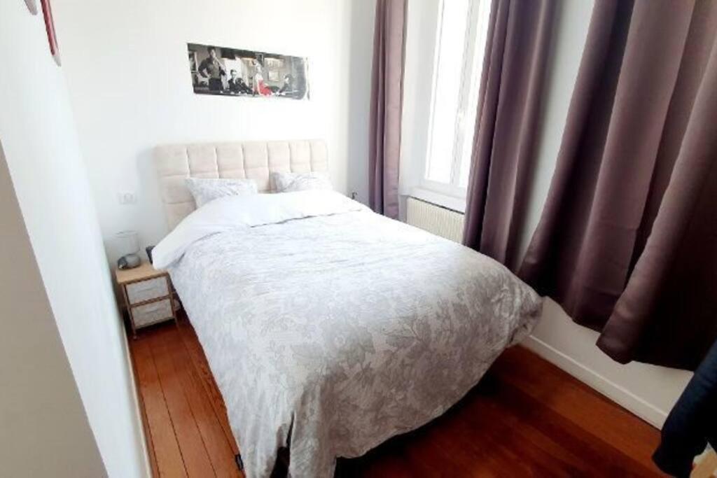 a bedroom with a white bed and a window at Le Domaine : maison proche de la plage et du port in Fécamp