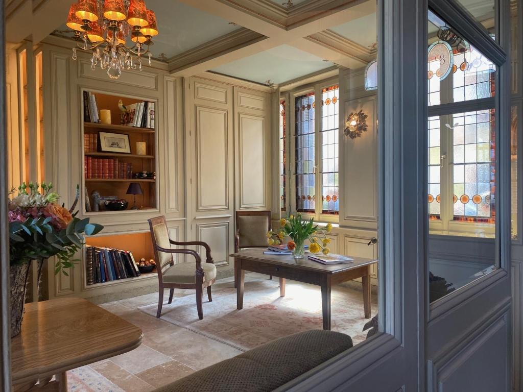 Una sala de estar con una mesa y sillas y una lámpara de araña. en La Petite Lucie, en Honfleur