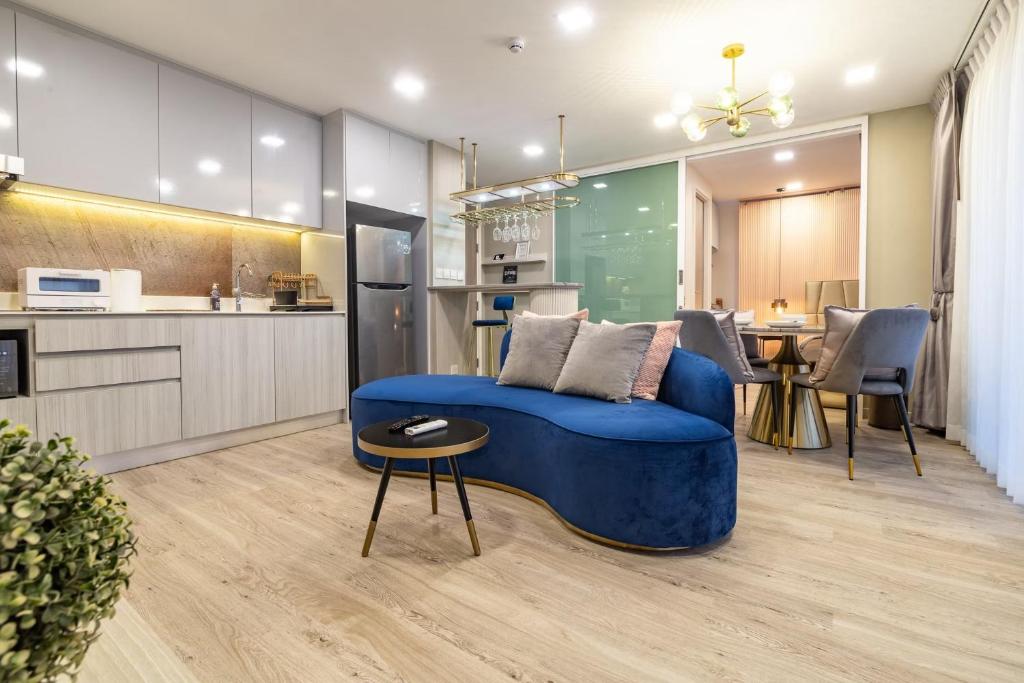 Huahin Stay في هوا هين: غرفة معيشة مع أريكة زرقاء ومطبخ