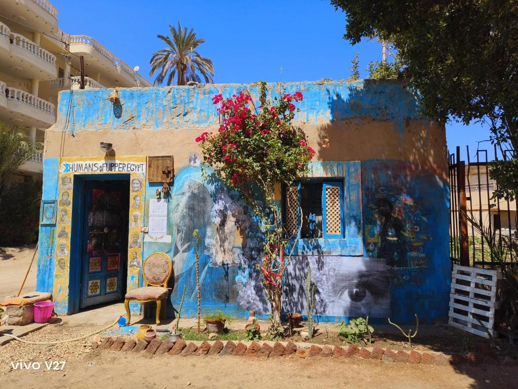 un edificio azul con una pintura a un lado en Humansofupperegyt, en Luxor