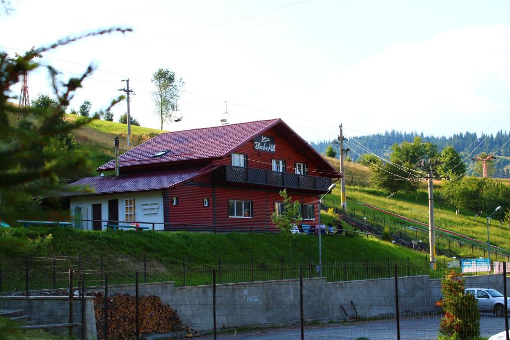 a red house on the side of a hill at Pensiunea Negrești in Vatra Dornei