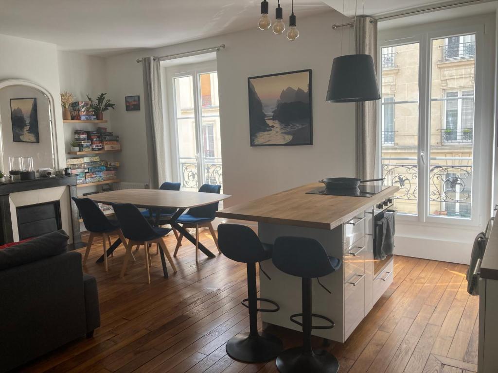 une cuisine et une salle à manger avec une table et des chaises dans l'établissement Appartement 3 pièces Paris 11e, à Paris