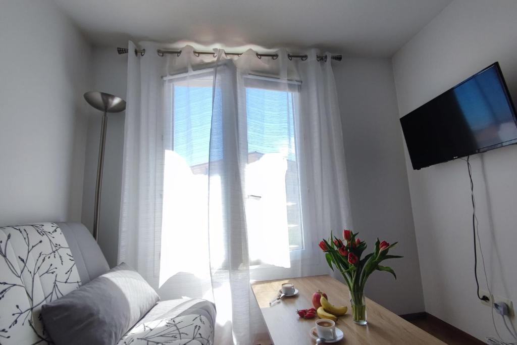 een woonkamer met een bank en een groot raam bij Charming studio 2 in Fréjus close to the beaches in Fréjus