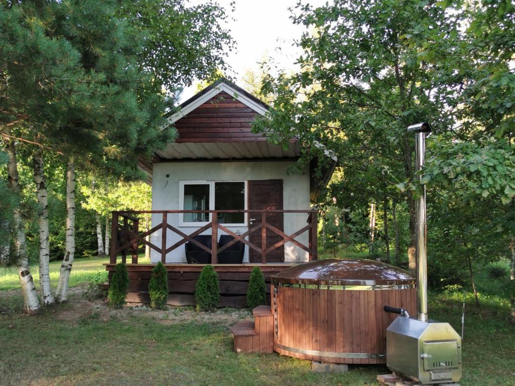 a small house with a hot tub in the yard at Līdumnieki in Vērgale