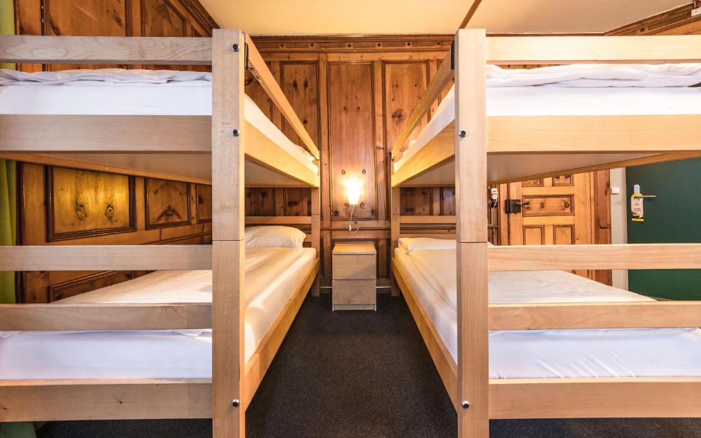 ダボスにあるHotel Montana by Mountain Hotelsのキャビン内の二段ベッド4台が備わる客室です。
