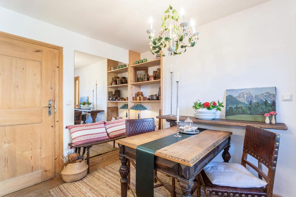 een eetkamer met een tafel en stoelen en een kroonluchter bij Ferienappartement 2 - Lockstein in Berchtesgaden