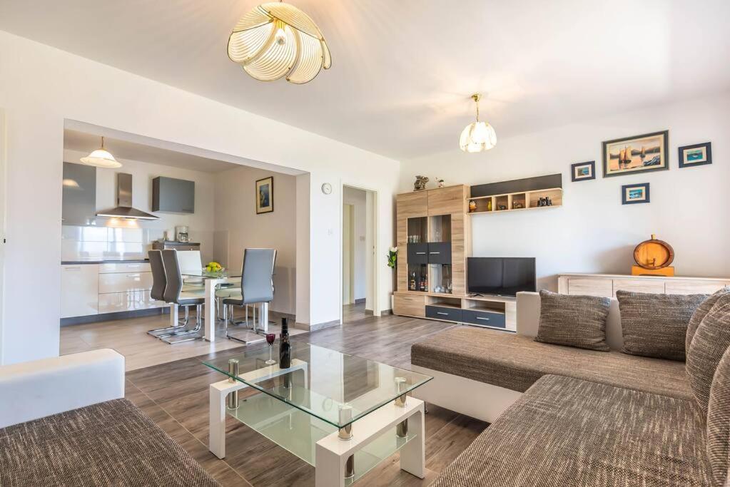 ein Wohnzimmer mit einem Sofa und einem Tisch in der Unterkunft Delux Sandy Beach (Duće) in Duće