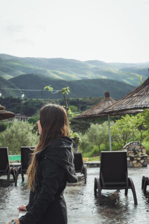 a woman is standing in the rain at Guesthouse Lord Byron in Tepelenë