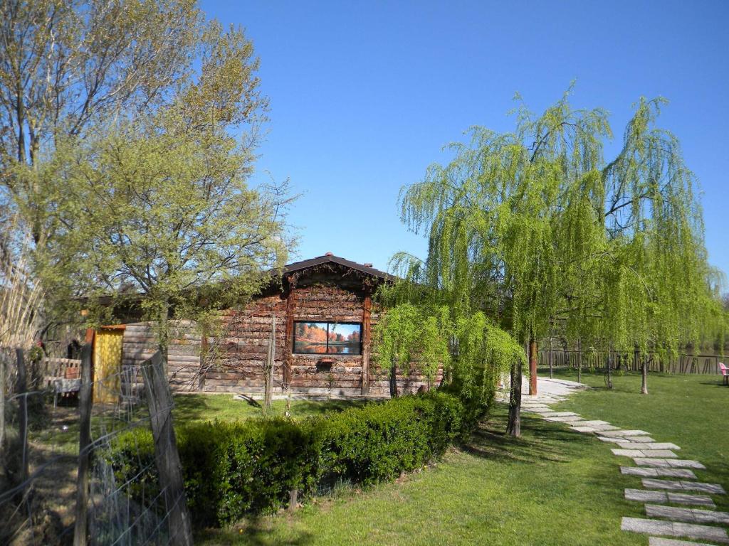 una baita di tronchi con un sentiero in pietra di fronte ad essa di Cascina Beneficio a Castelnuovo Bormida