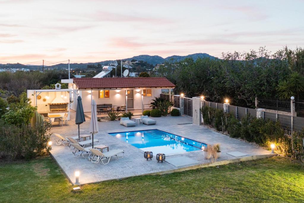 een achtertuin met een zwembad en een huis bij Reni Garden House in Afantou