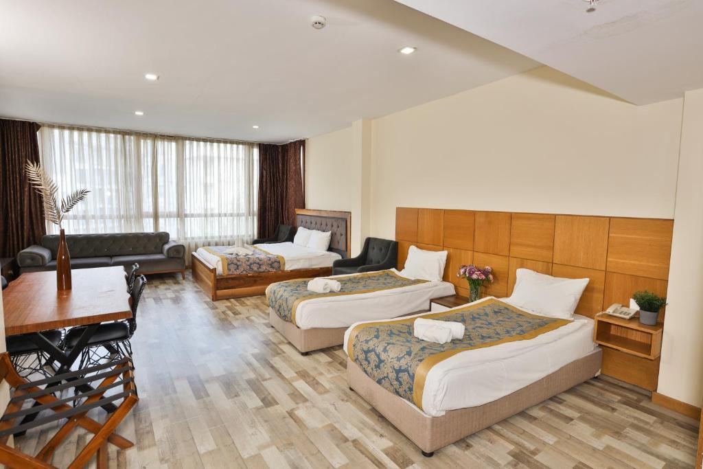 a hotel room with two beds and a living room at Cumbali Plaza Hotel in Istanbul