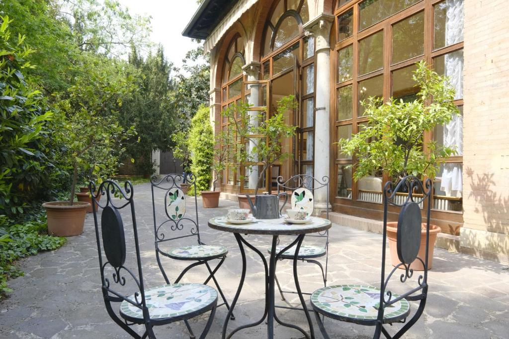een tafel en stoelen voor een gebouw bij Certosa di Ferrara Wonderful Villa x12! in Ferrara