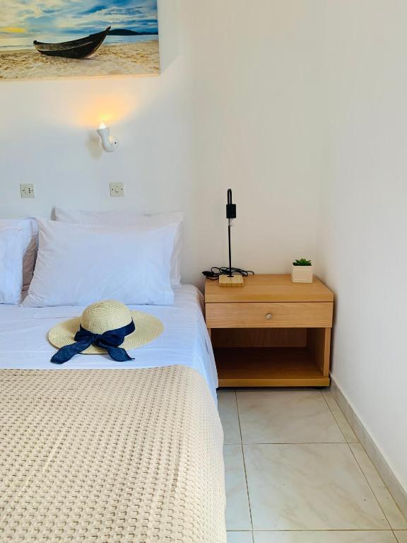 a hat is sitting on a bed in a bedroom at Skopelos Inn in Stafylos