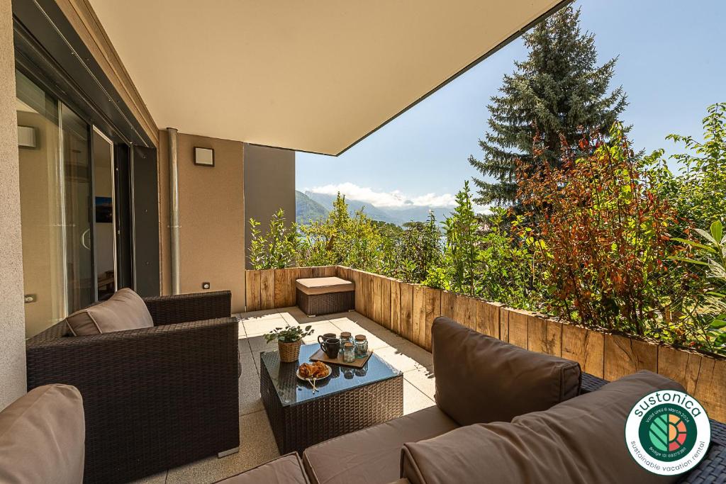 a patio with a couch and a table on a balcony at Aux balcons annéciens- Entre Lac et centre ville, LLA Selections by Location lac Annecy in Sévrier