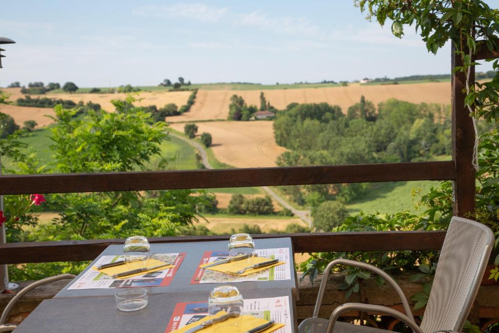 - une table avec des verres à vin et une vue dans l'établissement Logis - Le relais des deux vallées, à Salvagnac