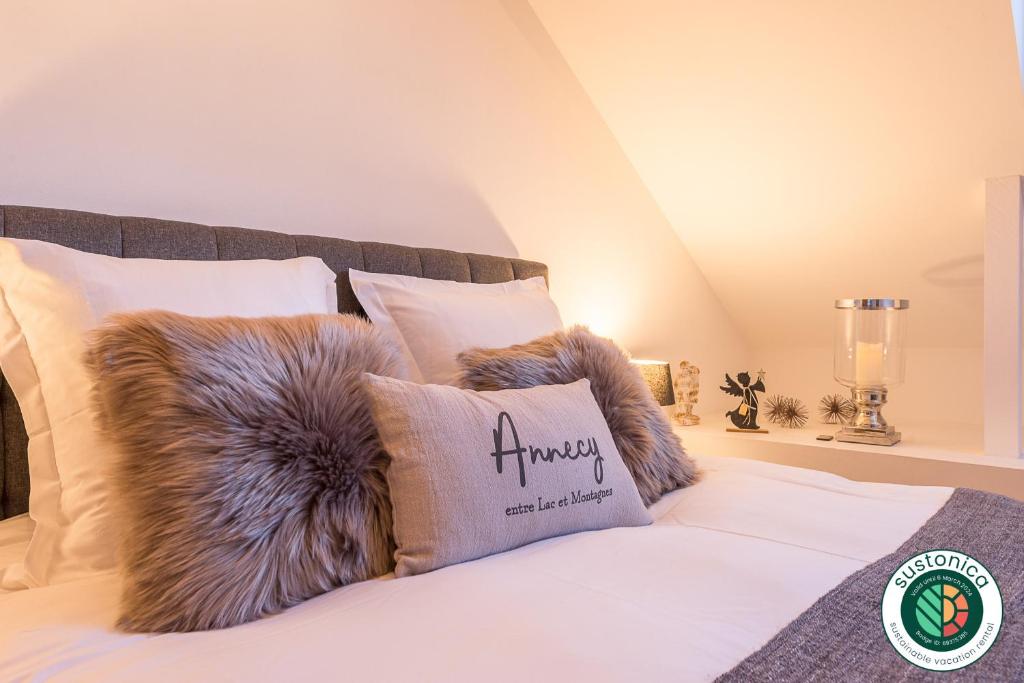 a white bed with a furry pillow on it at Charmantissime appartement avec vue montagnes - 3 ch, LLA Selections by Locationlacannecy in Saint-Jorioz