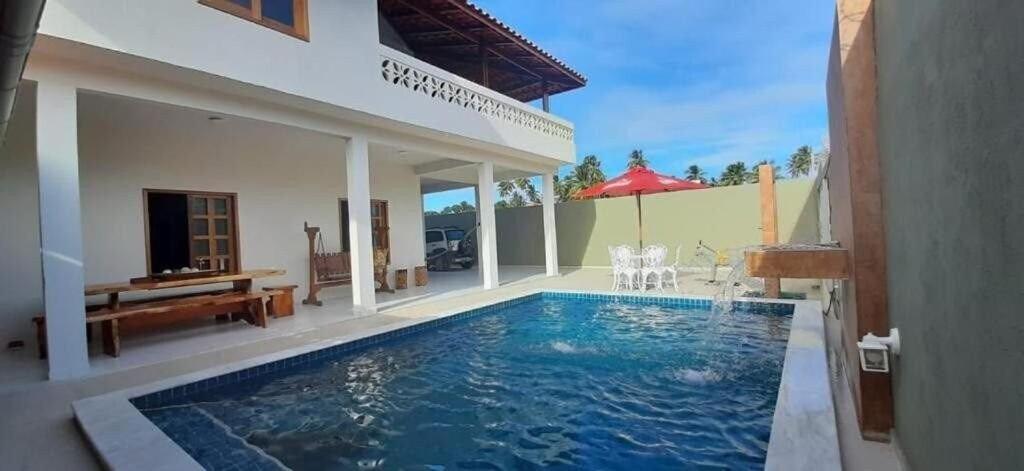 une villa avec une piscine en face d'une maison dans l'établissement Casa Viva Milagres, PX ao Réveillon dos Milagres, à São Miguel dos Milagres