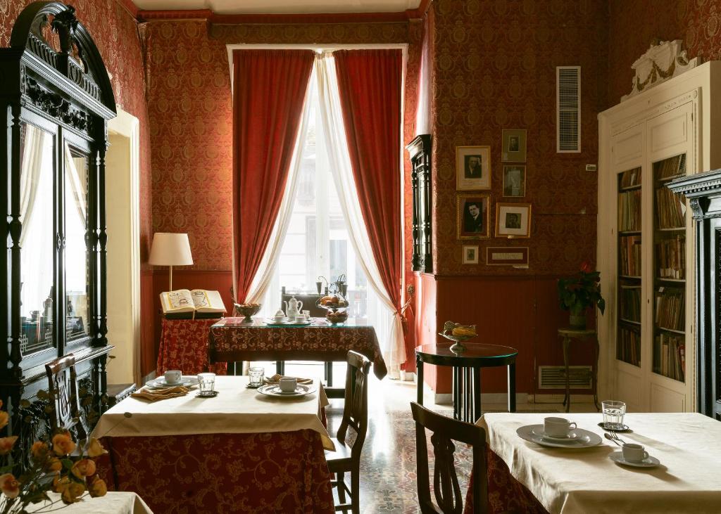 jadalnia z dwoma stołami i oknem w obiekcie Carafa di Maddaloni By Enjoy Napoli w mieście Napoli