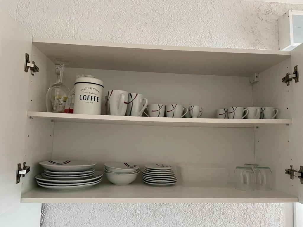a shelf with cups and plates in a kitchen at Apartment Marielena 2 in Püttlingen