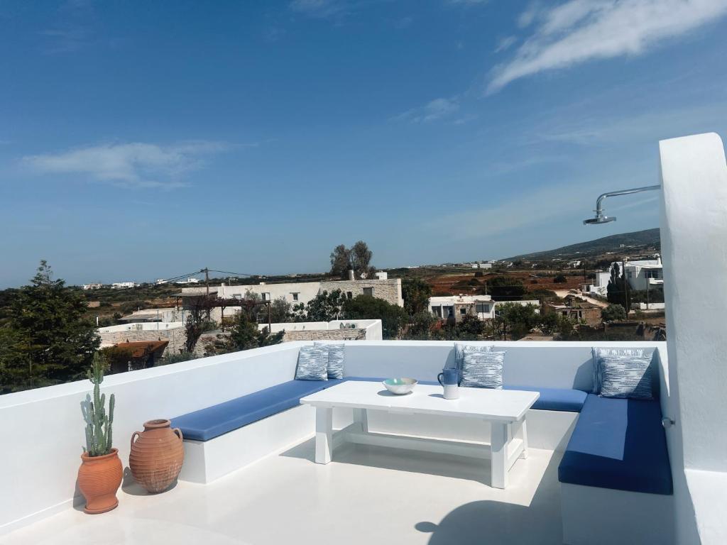 balcón con mesa blanca y sillas azules en Cavos Paros Boho Chic sea-view apartment in Aliki, en Aliki