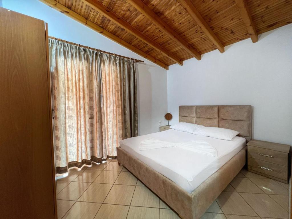 a bedroom with a bed and a large window at Alex Apartments in Sarandë