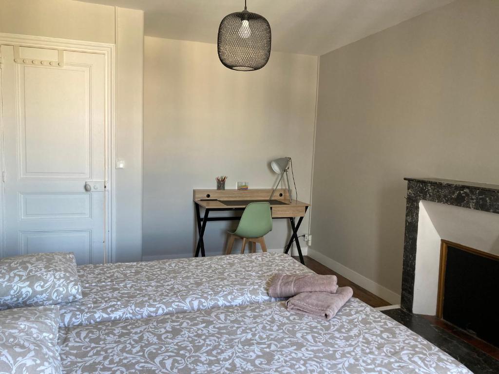 a bedroom with a bed and a desk at L'escale Granvillaise in Granville