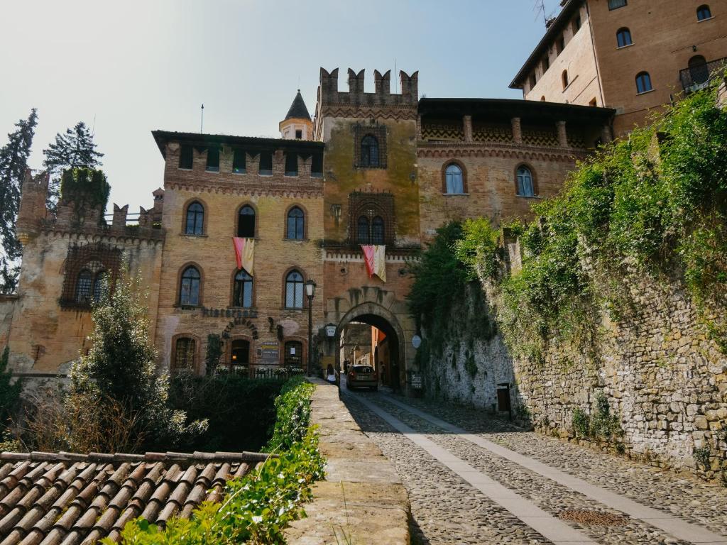 een oud kasteel met een boog ervoor bij Cora Aparthotel Stradivari in CastellʼArquato