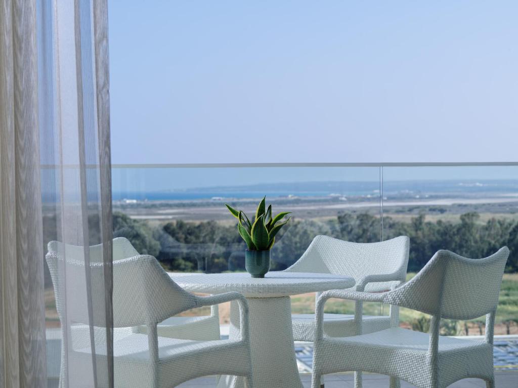 a table and chairs on a balcony with a view at City of Dreams Mediterranean - Integrated Resort, Casino & Entertainment in Limassol