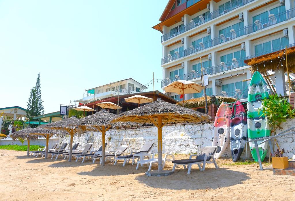a row of chairs and umbrellas on a beach at The Lord Nelson Hotel in Ban Chang