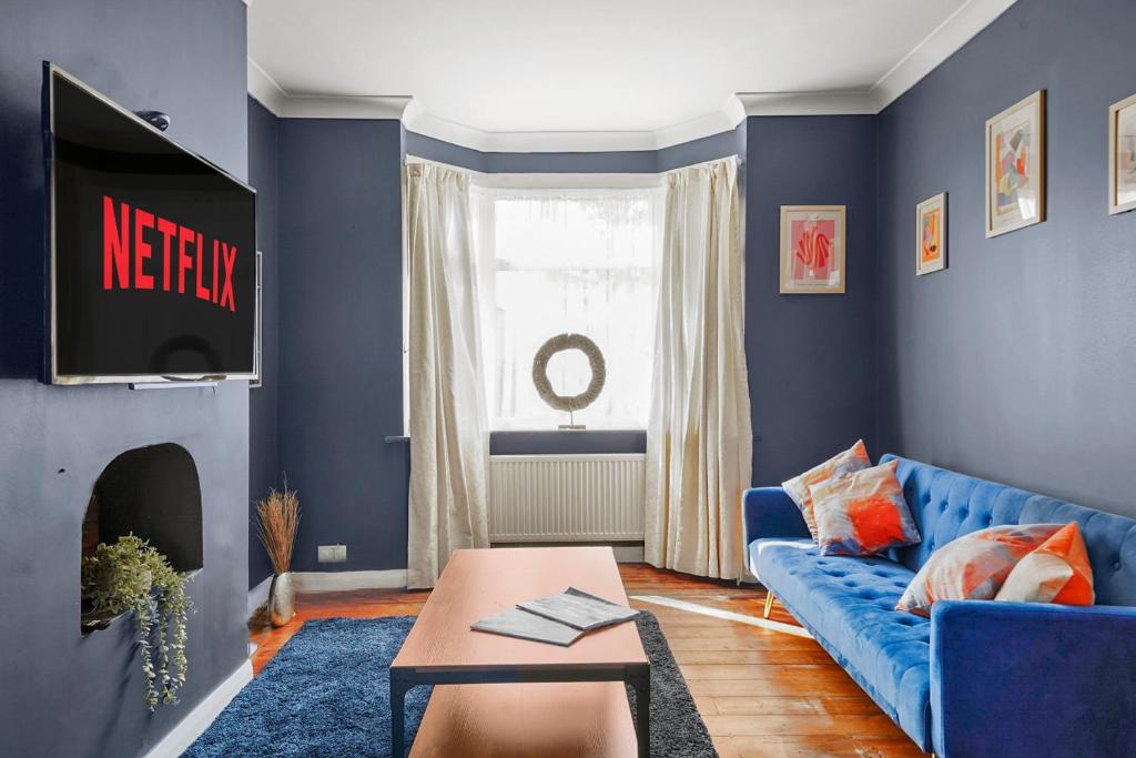 a living room with blue walls and a blue couch at Home at The Brent in Dartford