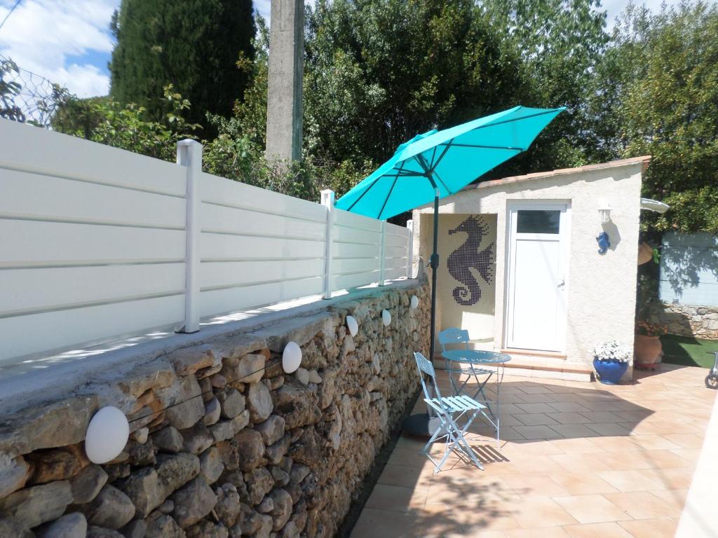 niebieski parasol na kamiennej ścianie w obiekcie La GARRIGUE w mieście Draguignan